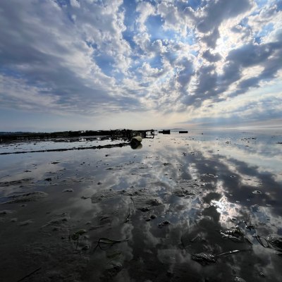 a group of clouds in the sky over a body of water